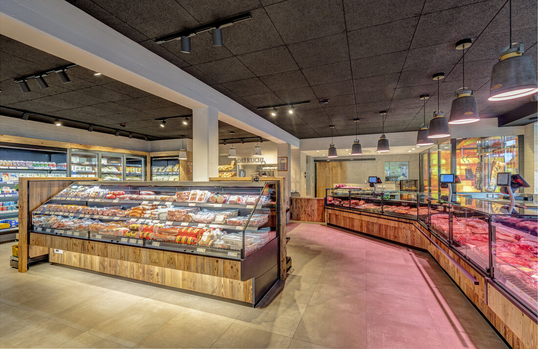 Karnerta verarbeitet am Produktions­standort in Klagenfurt das Fleisch von Tieren heimischer Landwirte und ist  Österreichs größter Hersteller von frisch vorgekochten Teigwaren. Am stark frequen­tierten Südring werden die Produkte direkt im Fleischfachmarkt an Geschäfts­ und Pri­vatkunden verkauft. Versprühten der Ver­kaufsraum und der angegliederte Imbiss mit Neonlicht, wandhoher Verfliesung und Edel­stahlmöbeln die Atmosphäre eines Fabrik­verkaufs aus vergangenen Zeiten, so präsen­tiert sich der Flagship­Store (200 m2) der Karnerta nach fünfwöchigem Umbau durch Aichinger nunmehr mit „Speckhimmel“ und Dry­ Age­ Reiferaum als „Dei Fleischer“. &nbsp; „Dei Fleischer“ in Klagenfurt „Karnerta verkauft Qualitätsfleisch mit regionaler Herkunft sowie hochwertige Teig­ und Wurstwaren. Das Shop­Design und das &hellip;