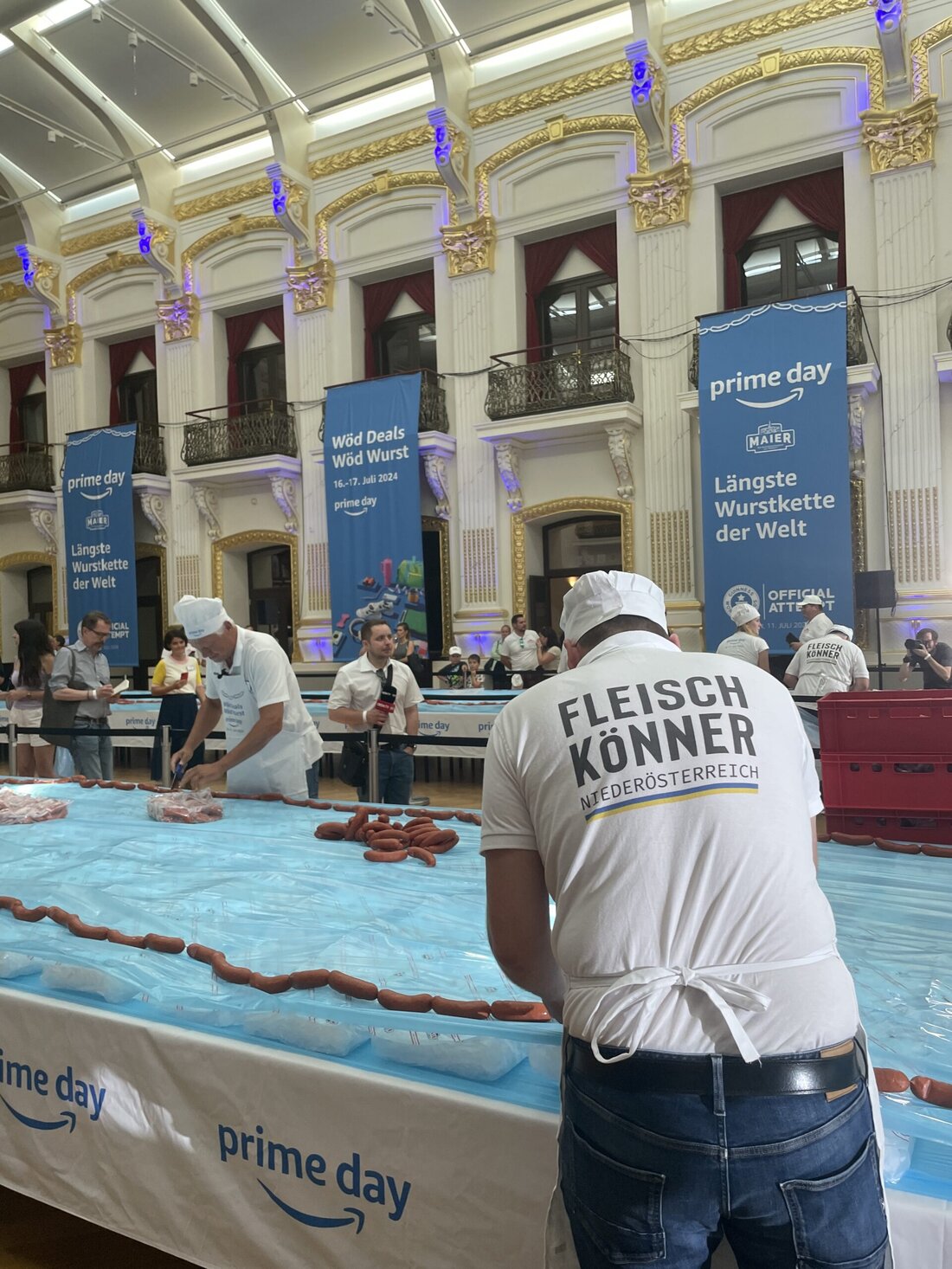 Die Hallen in den Sofiensälen waren zum Bersten voll. Gut gelaunte Fleischermeister, von Wolfgang Seidl bis Doris Steiner, liefen mit roten Kisten bewaffnet durch die ehrwürdigen Räume in der Marxergasse 17 im 3. Wiener Gemeindebezirk. Aber nicht nur die Fleisch-Könner waren als helfende Hände vor Ort, sondern auch die Lebensmittelakademie des österreichischen Gewerbes rund um Veronika Vernes, die dieses hochkarätig besetzte Event unter anderem auch mitorganisiert hatte. Die längste Wurstkette der Welt ist 100 % aus Österreich Selbst Gramiller-Chef Dipl.-Ing. Gerhard Pockenauer-Gramiller und AMA-Marketing Fleisch-Manager Dr. Rudolf Stückler ließen es sich nicht nehmen, bei diesem österreichischen Weltrekordversuch live dabei zu &hellip;