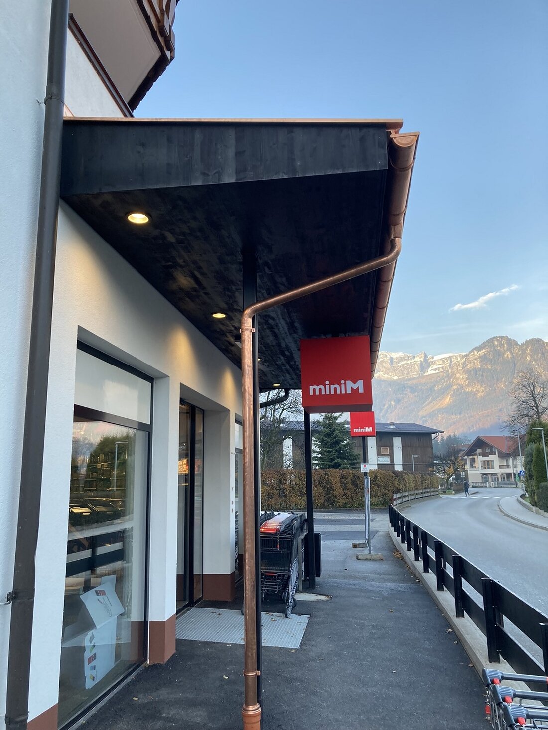 Einer der größten Vorzüge der minim-Geschäfte ist, dass sie sich meist in zentraler Lage in den Ortschaften befinden. Nach Möglichkeit wird ein bestehender Leerstand genutzt und für das innovative Supermarktkonzept angepasst. So auch in Radfeld. In den Räumlichkeiten befand sich zuvor ein Drogeriemarkt. Im Zuge der Adaptierung konnte die Verkaufsfläche vergrößert werdenund beträgt nun ca. 250 m. Dadurch war es auch möglich, ein kleines Café mit Sitzbereich zu integrieren. Gestalterisch fügt sich der Markt harmonisch in das eher ländliche Gebiet ein, der Außenbereich wurde behutsam an die bestehenden Gebäude in der Umgebung angepasst. Der Markt ist vom Dorfgebiet aus optimal zu …