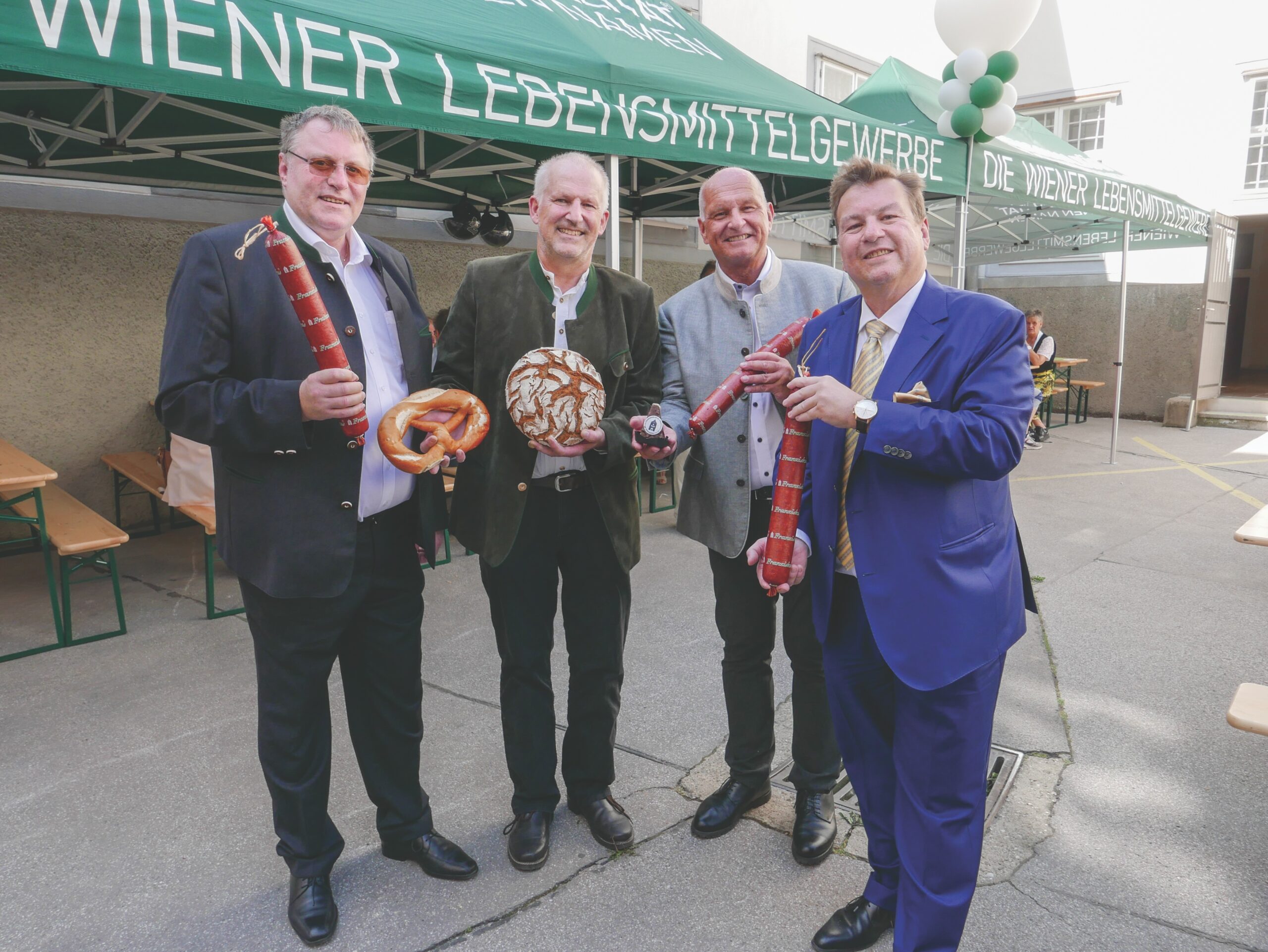 Gremialobmann Agrarhandel KommR Ewald Schwarz, Obmann des Bundesverbandes der österr. Bäcker KommR Josef Schrott, LI-GF Dr. Klaus Puza und LIM-Stv. KommR Horst Stierschneider (v.l.n.r.) präsentierten die Kirtags-Schmankerln Franziskus-Wurst, -Brot und -Spitz.