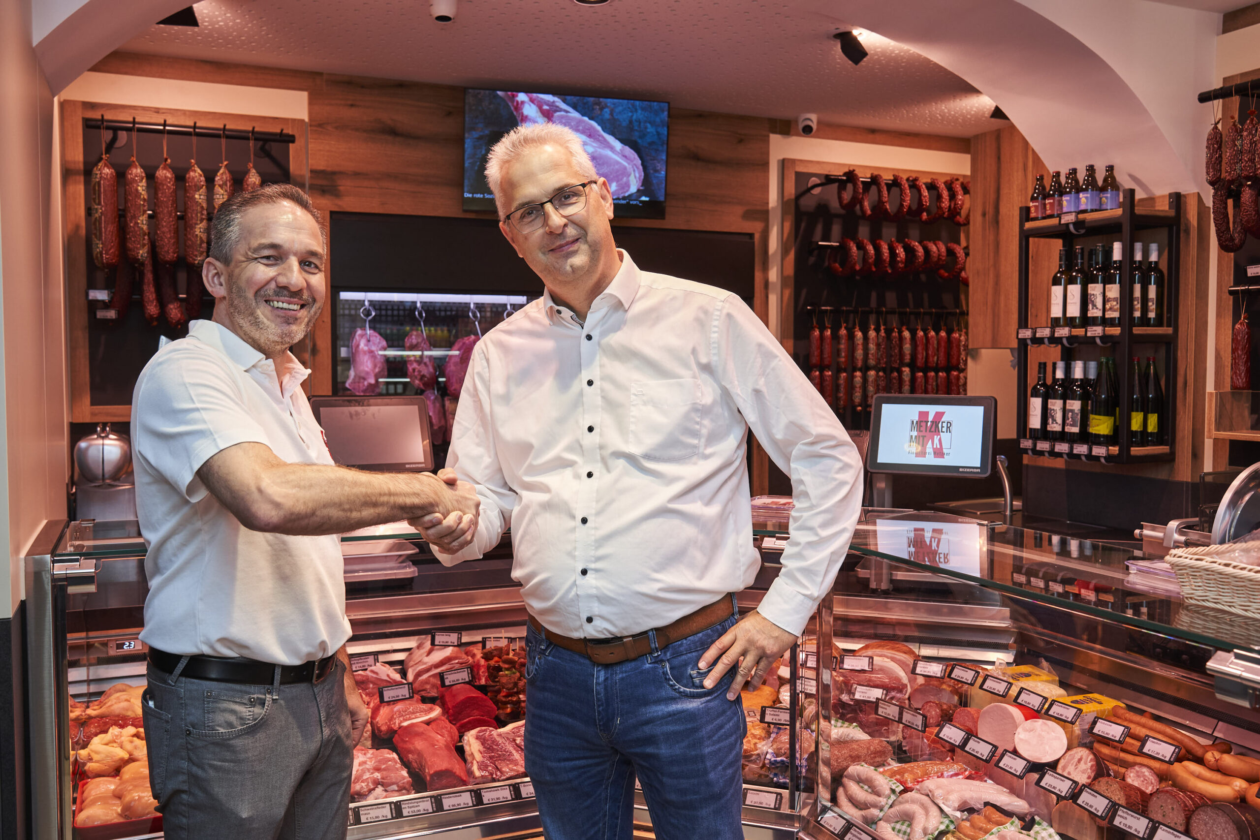 Fleischermeister Christian Metzker (links) und Thomas Hanke von Hanke Ladenbau freuen sich über das gelungene Projekt. Gemeinsam setzten sie auf energieeffiziente Technik und zeitgemäßes Design für den letzten Fleischer in Hernals.