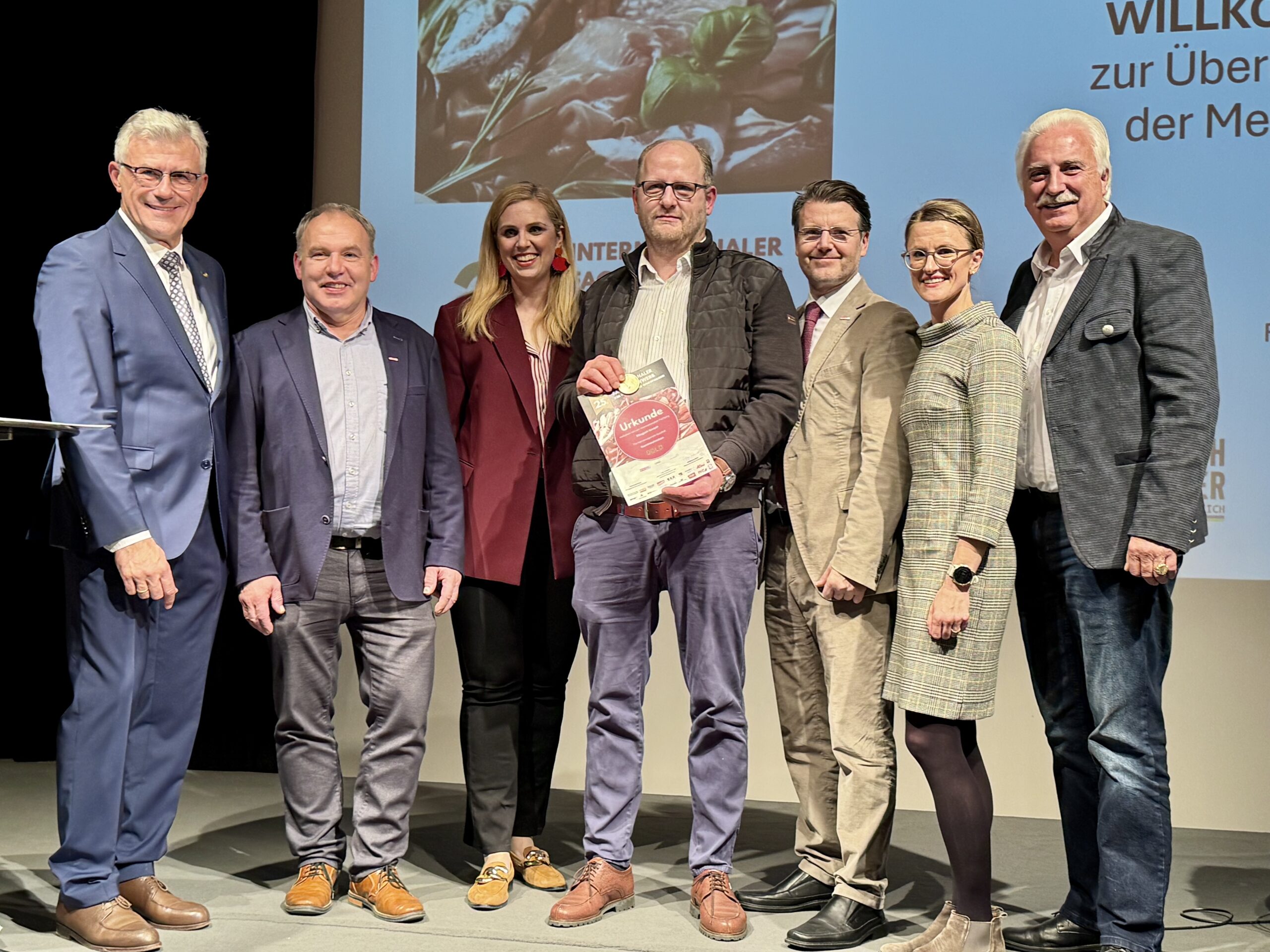 Gratulation an die Fleischerei Ellegast GmbH zu ihrem Erfolg beim IFFW 2025. Auf dem Foto (v. l. n. r.): Fleischermeister und Oberjuror Wolfgang Seidl, NÖ-Innungsmeister Jakob Ellinger, Abg. z. NÖ-Landtag Marlene Zeidler-Beck, die Fleischerei Ellegast GmbH, Bezirksstellenobmann Thomas Hagmann, Veronika Vernes, Geschäftsführerin der Lebensmittelakademie, sowie Bundesinnungsmeister Raimund Plautz.Bildcredit: Braune/Fleisch & Co
