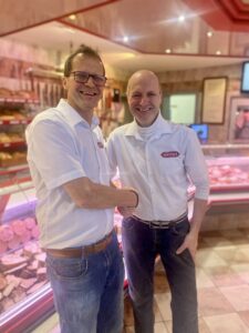 Ein Moment des Übergangs: Siegfried Zehetner übergibt nach mehr als vier Jahrzehnten im Betrieb an seinen Bruder Johannes – ein Handschlag, der für Vertrauen, familiäre Kontinuität und gelebtes Fleischerhandwerk steht.