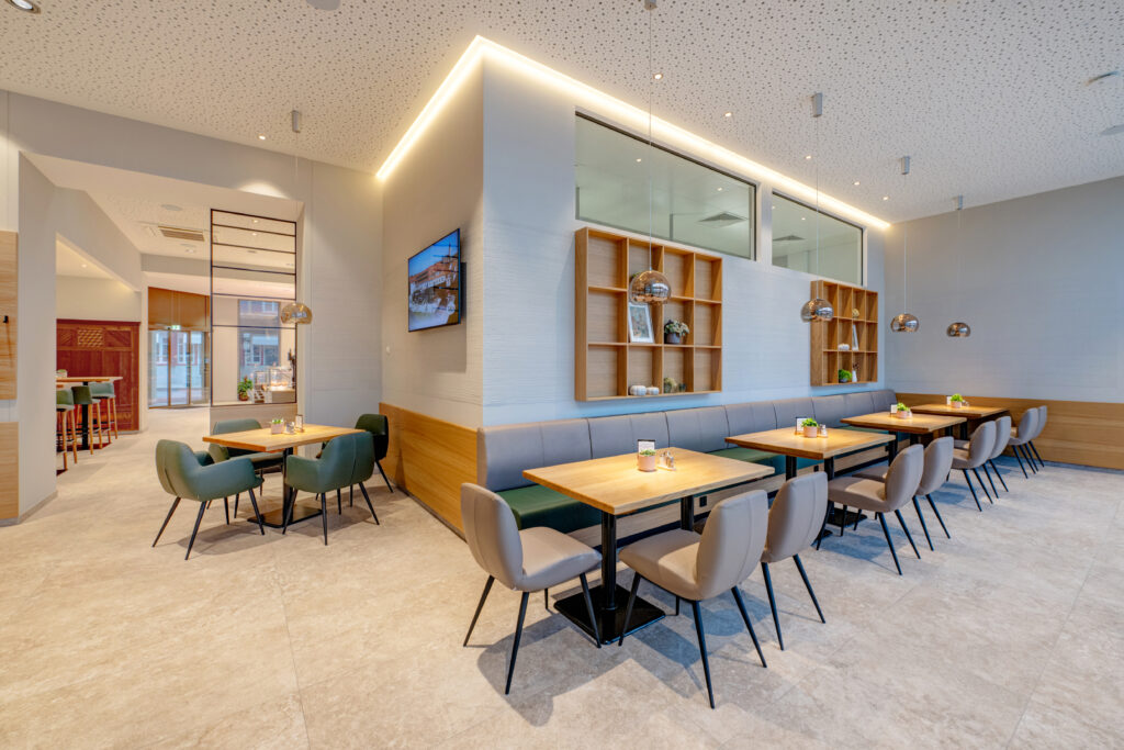 Holz, warme Erdtöne und lindgrüne Polster schaffen eine Atmosphäre mit Charakter. © Michaela Begsteiger