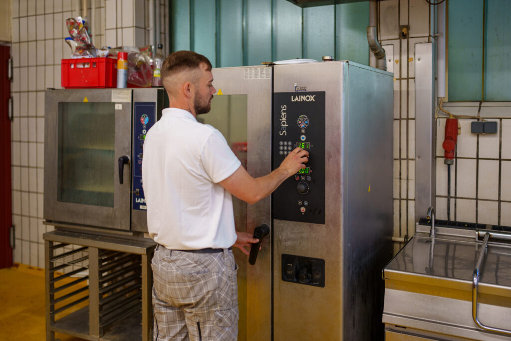 Vakuumverpackung der Würste an einer Kammer-Vakuummaschine von VC999. © Henry Gasselich