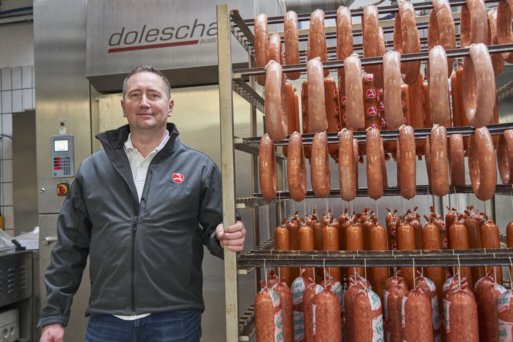 Fleischermeister Andreas Amstler vor dem Räucherwagen. Moderne Räuchertechnik von Doleschal unterstützt die Herstellung der Wurstspezialitäten. © Herbert Lehmann